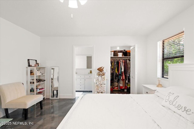 bedroom with a spacious closet, finished concrete floors, and a closet