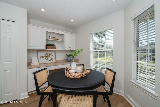 dining space with recessed lighting, baseboards, light wood-style flooring, and a textured ceiling