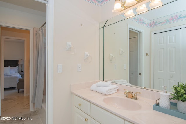 full bath featuring marble finish floor and vanity