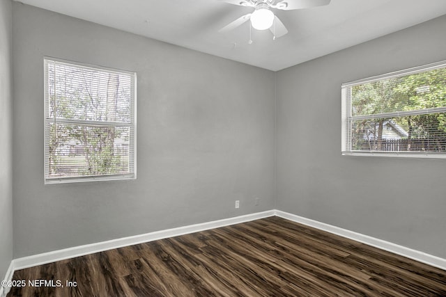 unfurnished room featuring dark wood finished floors, baseboards, and ceiling fan