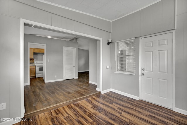 entrance foyer with dark wood-style floors, baseboards, and crown molding