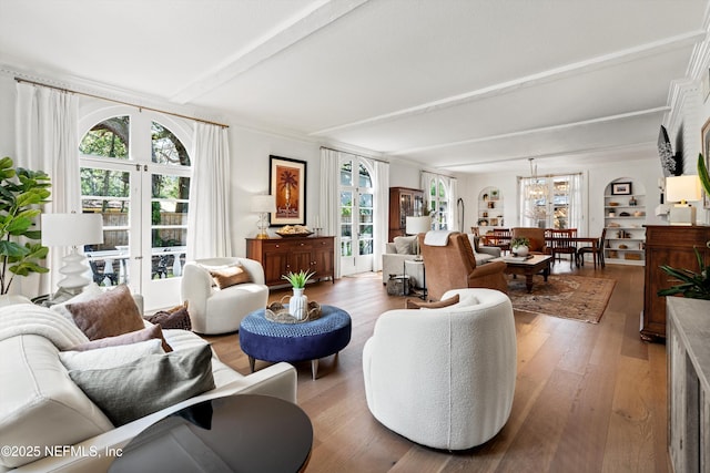 living area with a chandelier, hardwood / wood-style floors, and beam ceiling