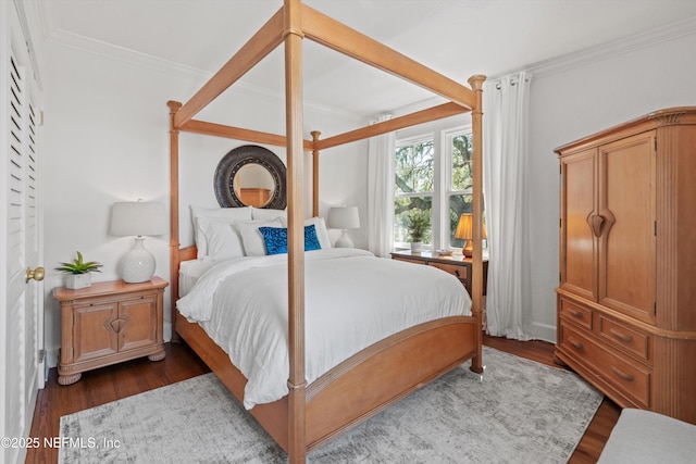 bedroom featuring ornamental molding, beam ceiling, and dark wood finished floors