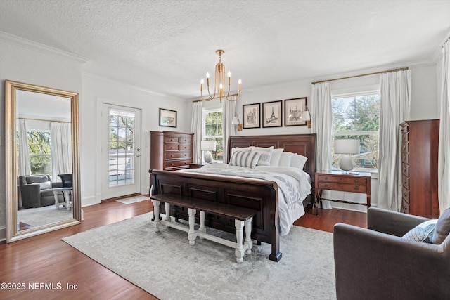 bedroom with access to exterior, multiple windows, ornamental molding, and wood finished floors