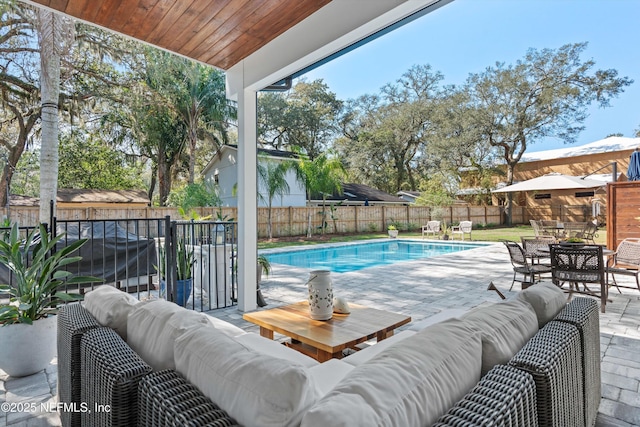 view of swimming pool with a patio, outdoor lounge area, a fenced backyard, and a fenced in pool