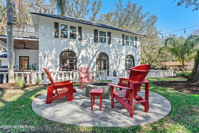 rear view of house featuring a fire pit, a patio area, and fence