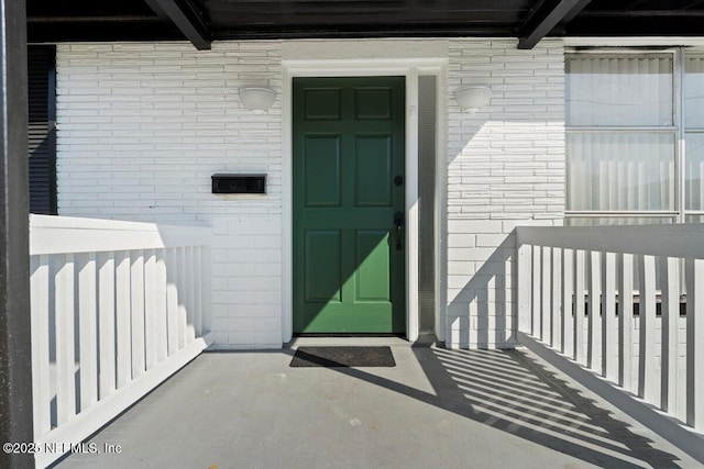 view of exterior entry featuring brick siding