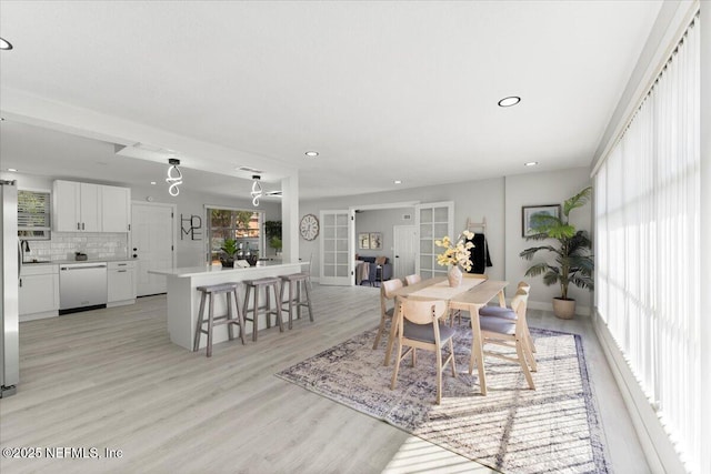 dining space featuring light wood finished floors and recessed lighting