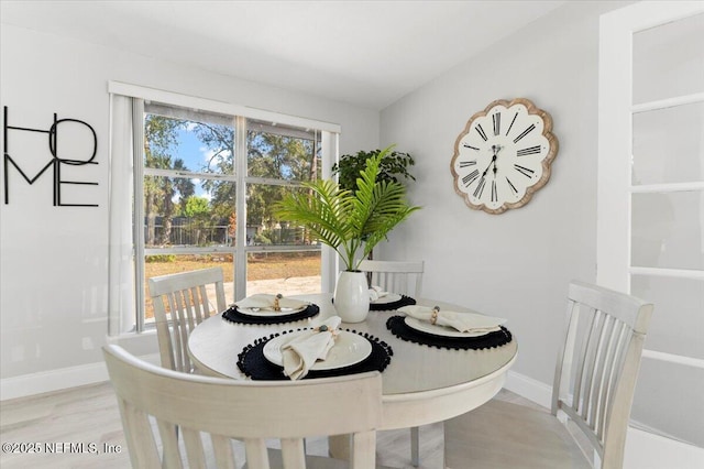 dining space with baseboards and wood finished floors