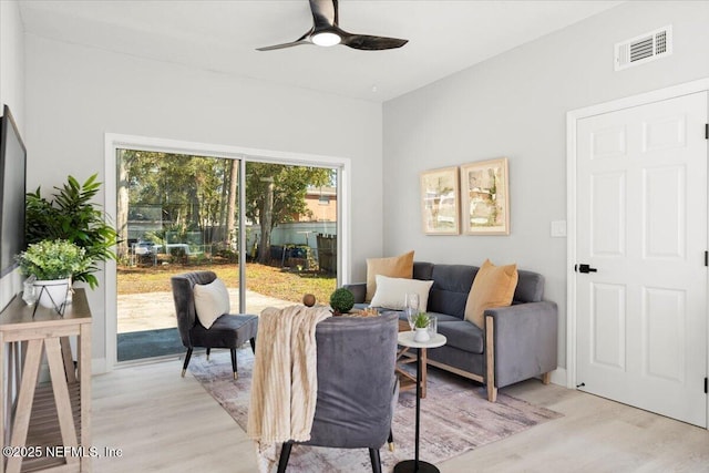 interior space with a ceiling fan, visible vents, and light wood finished floors