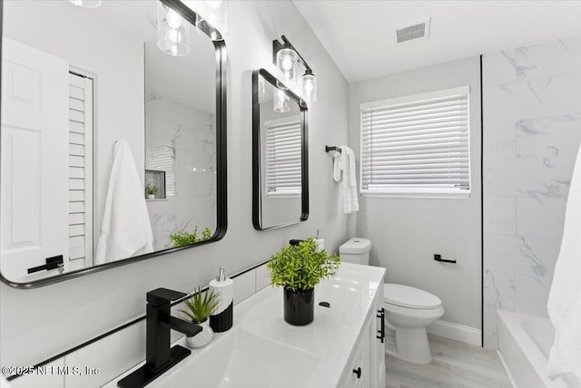 bathroom featuring toilet, baseboards, visible vents, and vanity