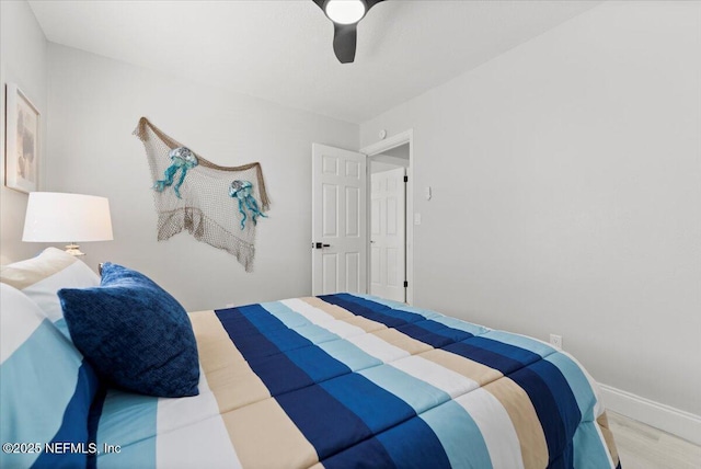 bedroom featuring ceiling fan, baseboards, and wood finished floors