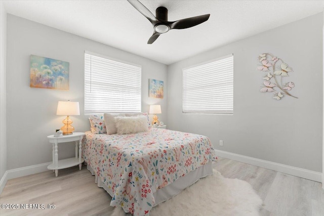 bedroom with a ceiling fan, baseboards, and wood finished floors