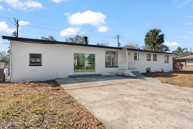 view of front of property with concrete block siding and a patio area