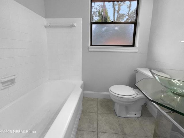 bathroom with tile patterned floors, toilet, and baseboards