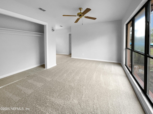 unfurnished bedroom with ceiling fan, visible vents, baseboards, a closet, and carpet