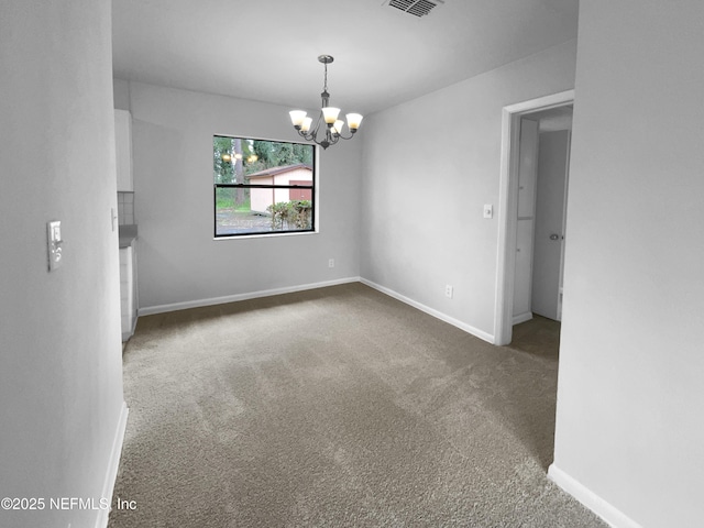 carpeted empty room featuring visible vents, baseboards, and an inviting chandelier