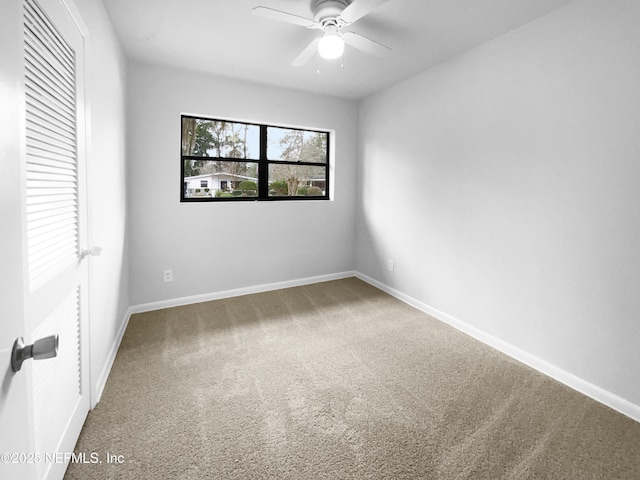 unfurnished room with carpet floors, baseboards, and a ceiling fan