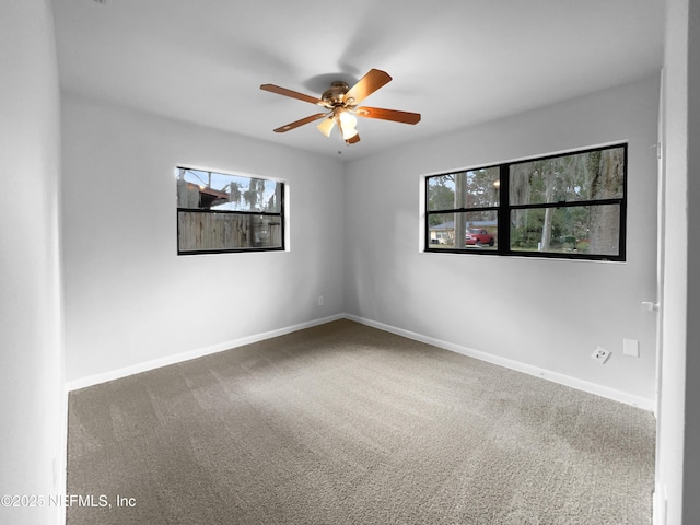 spare room featuring carpet flooring, a ceiling fan, and baseboards