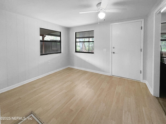 unfurnished room with ceiling fan, baseboards, and wood finished floors