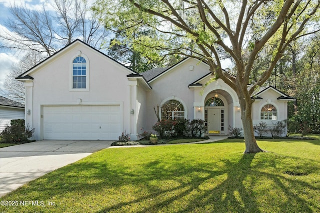 view of front of house featuring a front yard, driveway, and stucco siding