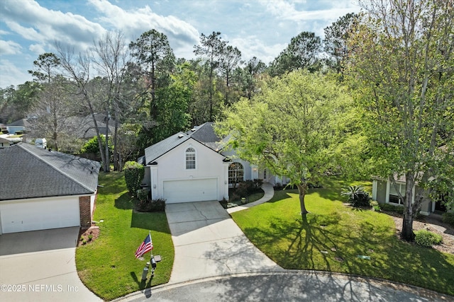 view of front of home with a garage, a front yard, driveway, and stucco siding