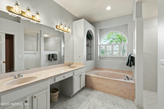 full bath with marble finish floor, a garden tub, double vanity, a sink, and a walk in shower