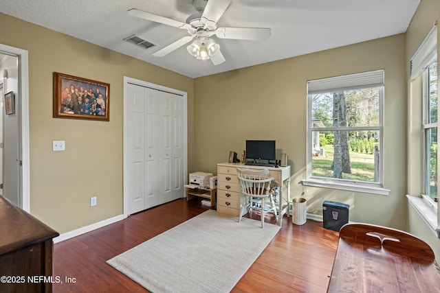 office area featuring baseboards, visible vents, ceiling fan, and wood finished floors