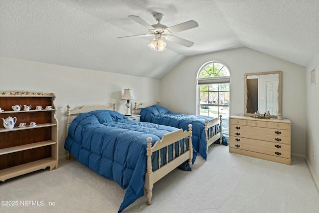 bedroom with vaulted ceiling, a textured ceiling, light carpet, and a ceiling fan