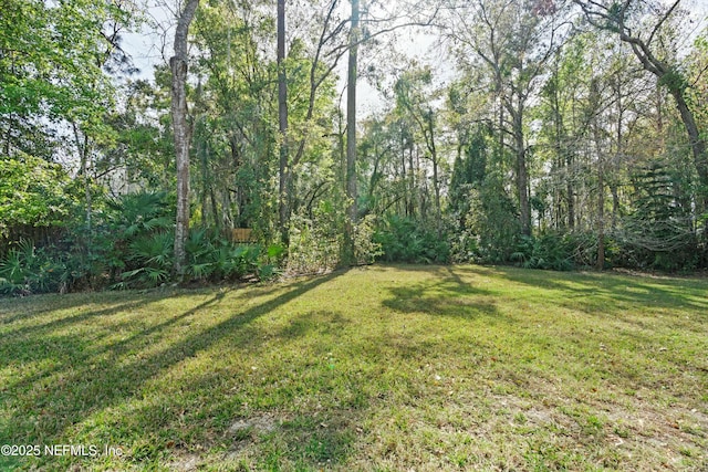 view of yard featuring a forest view