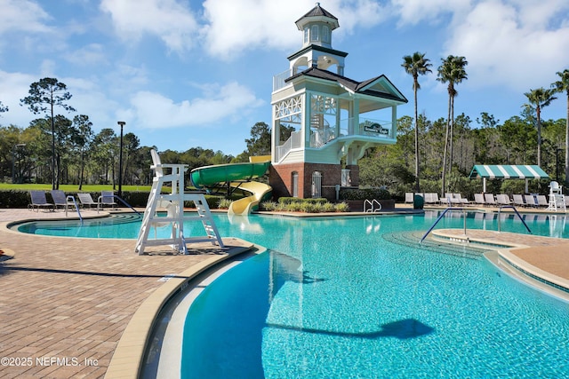 pool with a patio area and a water slide