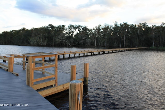 view of dock featuring a water view and a wooded view