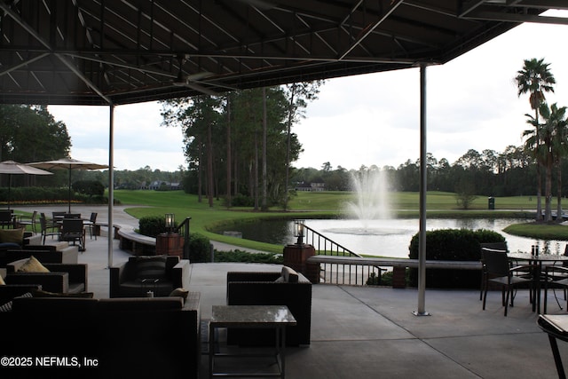 exterior space with a water view, an outdoor living space, a lawn, and a patio