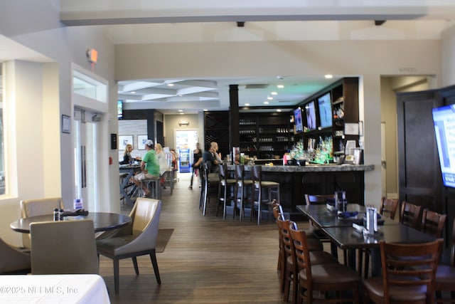 dining area with a community bar, recessed lighting, and wood finished floors