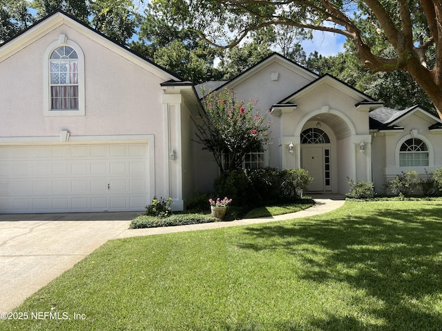 view of front of house featuring a garage, concrete driveway, a front lawn, and stucco siding