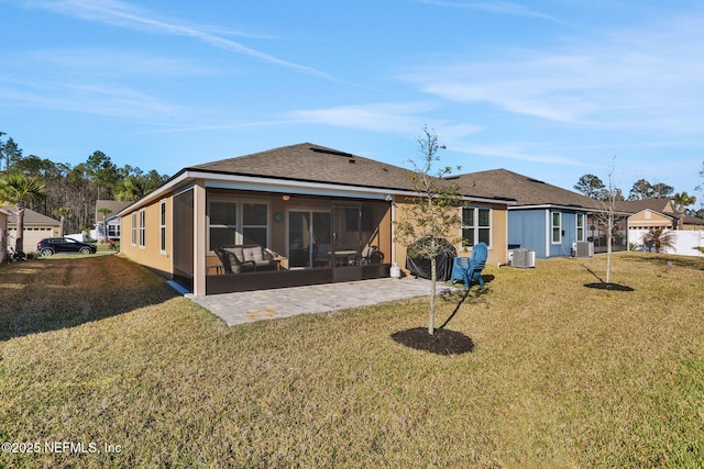 rear view of house featuring a sunroom, a lawn, central air condition unit, and a patio