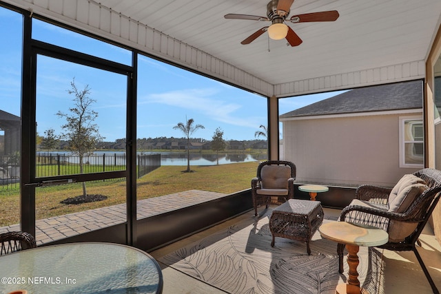 sunroom / solarium featuring ceiling fan and a water view