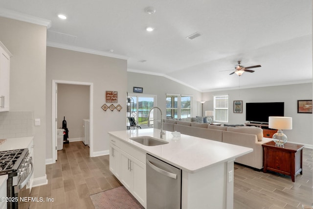 kitchen with wood finish floors, stainless steel appliances, tasteful backsplash, visible vents, and a sink