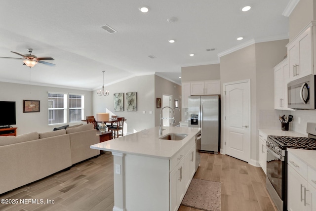 kitchen with stainless steel appliances, light countertops, a sink, and light wood finished floors