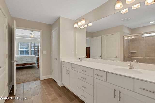 full bathroom featuring a sink, a tile shower, ensuite bathroom, and double vanity