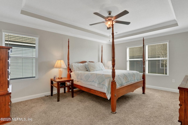 bedroom featuring a tray ceiling, light colored carpet, and baseboards