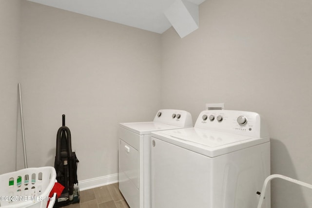 clothes washing area with wood finish floors, laundry area, baseboards, and separate washer and dryer