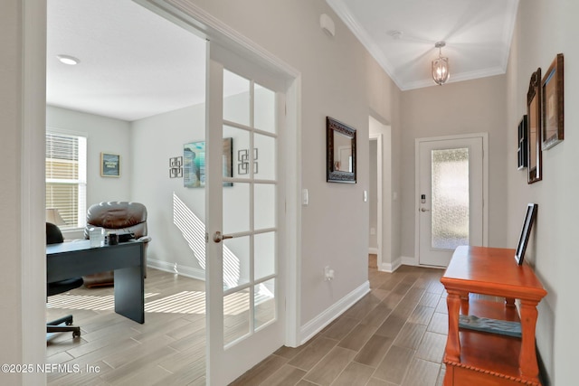 doorway with wood finish floors, french doors, crown molding, and baseboards