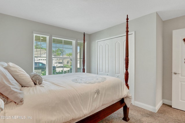 bedroom with carpet, baseboards, and a closet