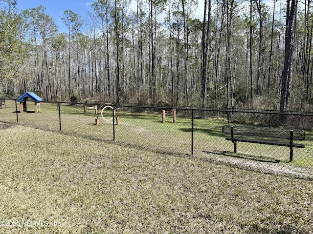 view of property's community featuring a yard and fence