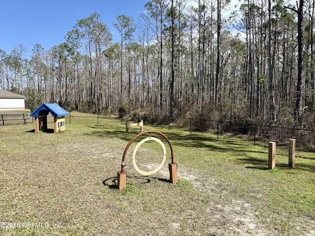 view of yard featuring fence and a wooded view