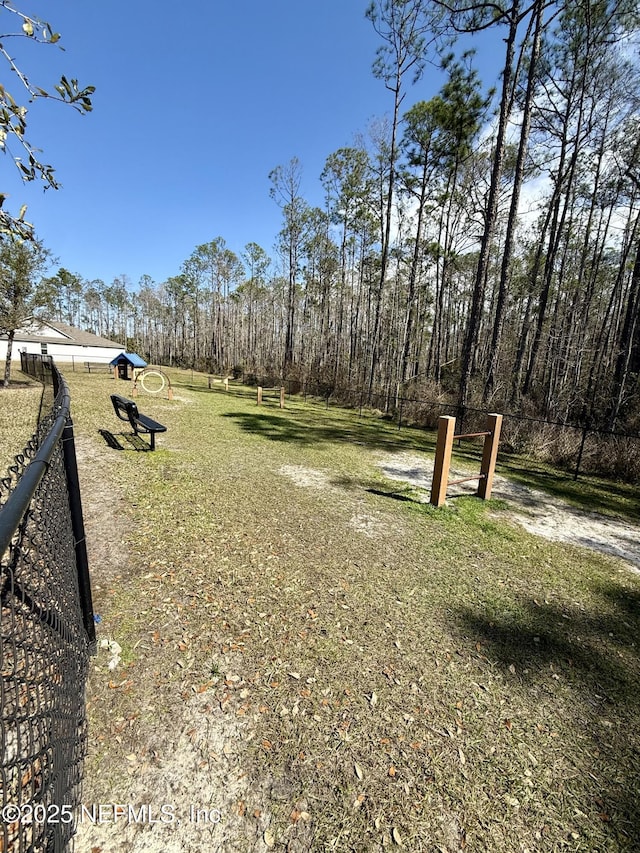 view of community with a lawn and fence