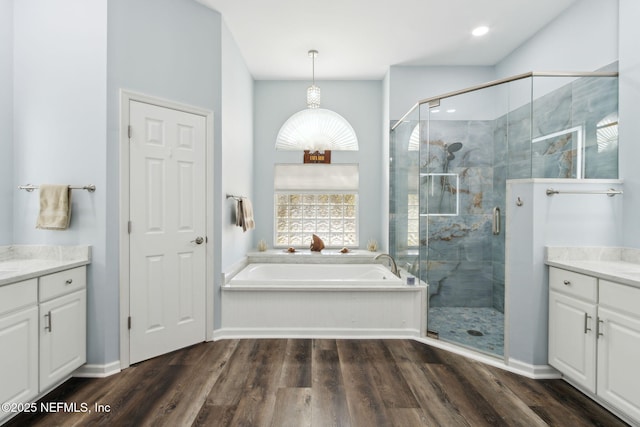 full bath featuring a garden tub, wood finished floors, vanity, and a shower stall