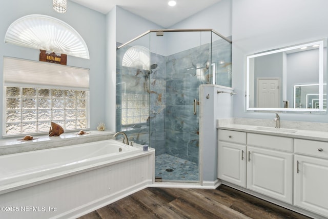 bathroom with vanity, a stall shower, wood finished floors, and a bath