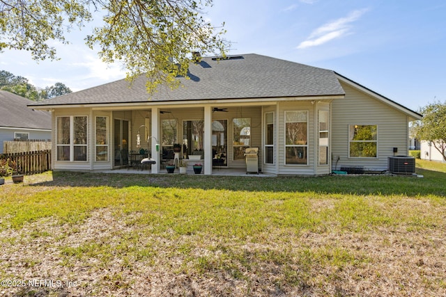 back of house with a patio, roof with shingles, fence, cooling unit, and a yard